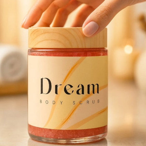 Hand holding a jar of 'Dream Body Scrub' with a blurred background